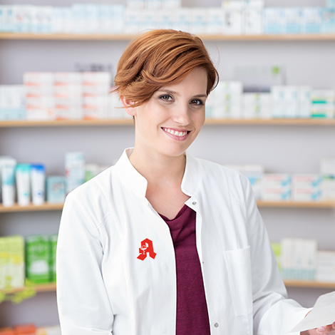Junge Apothekerin lächelt in Kamera